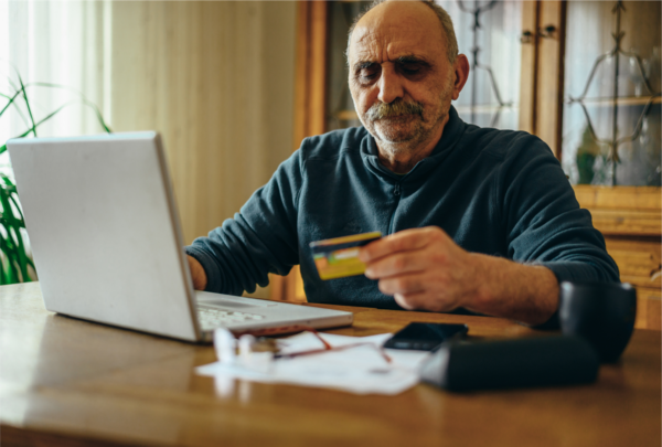 Senior Man Using A Laptop And Holding A Credit Car 2023 11 27 04 50 46 Utc 1